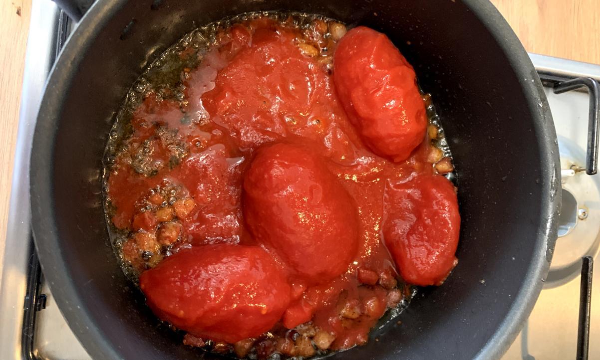 peeled plum tomatoes in a pan