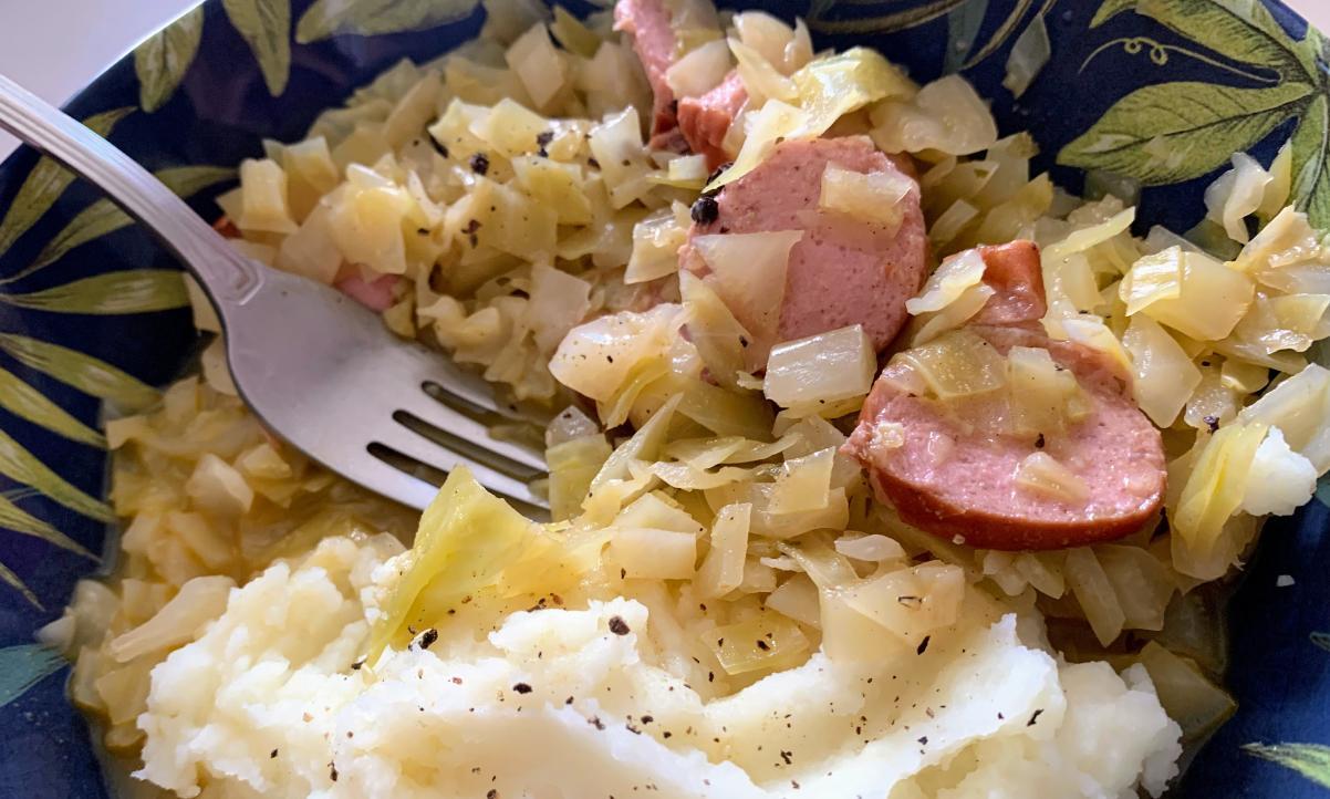 cabbage and smoked sausage in a bowl with a fork