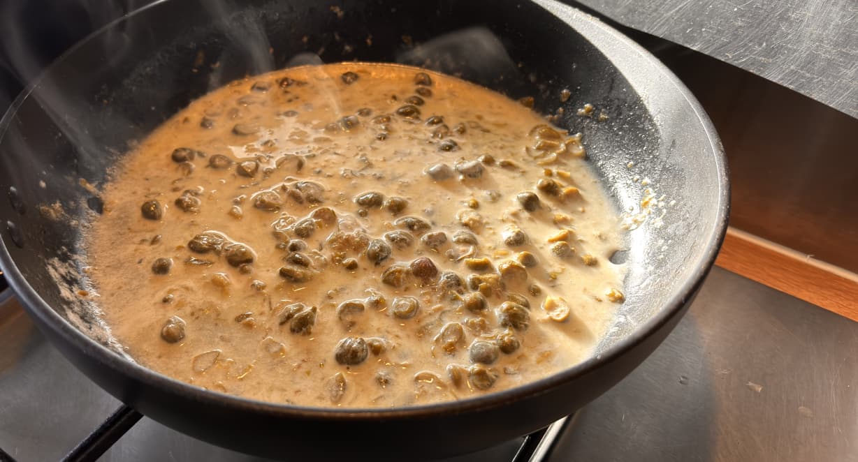 creamy caper sauce frying in a pan