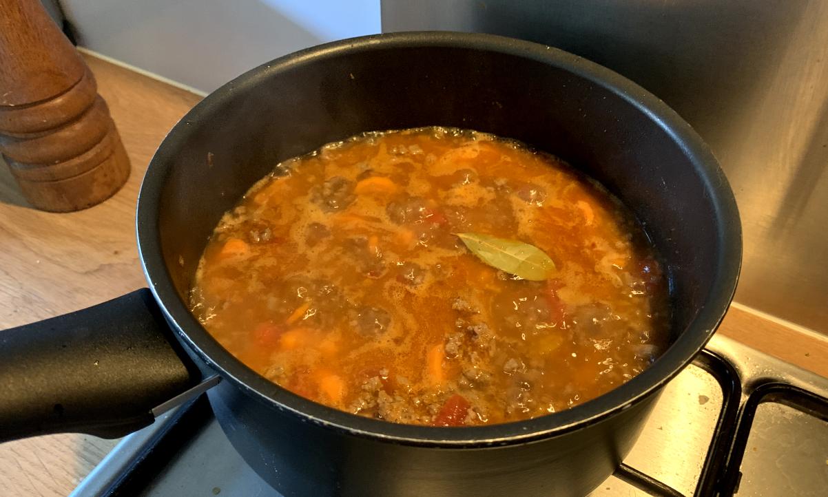 orange simmering water with a bayleaf floating on top