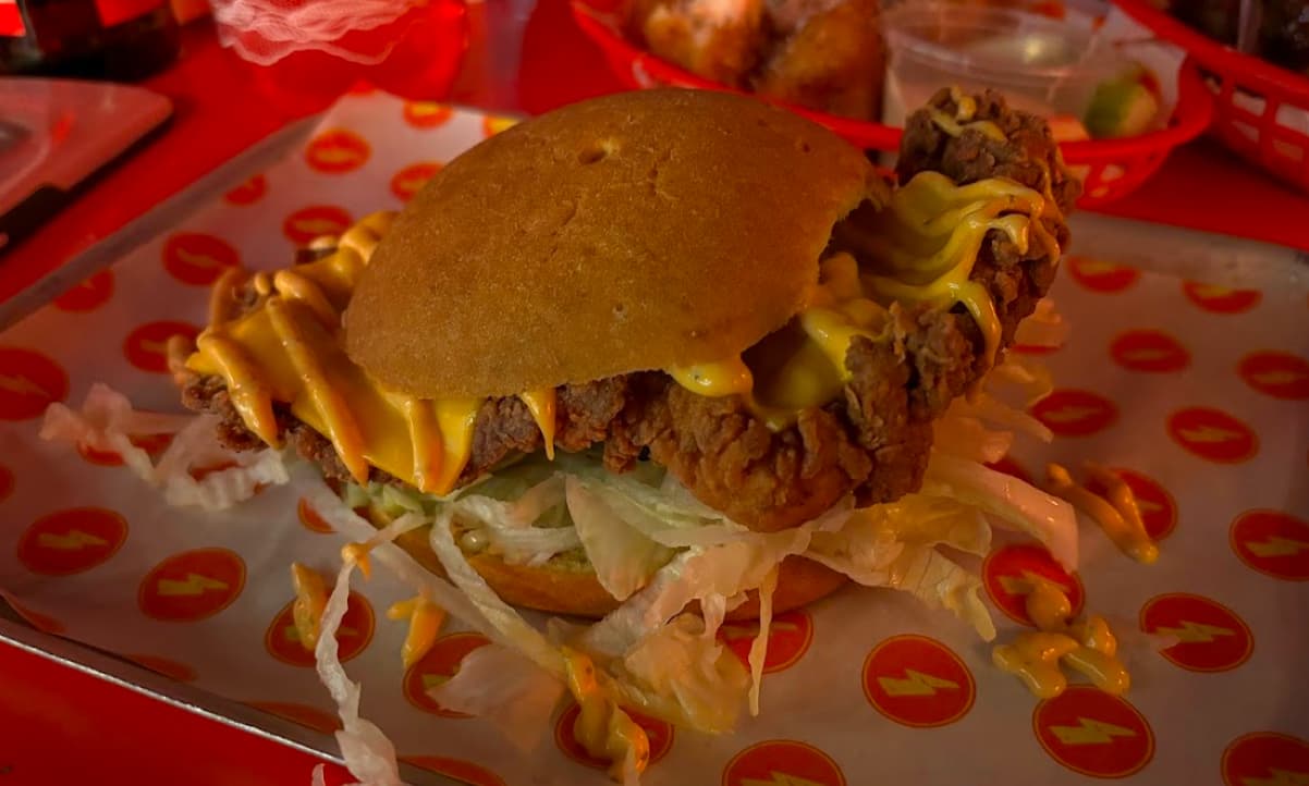 a gluten free chicken burger garnished with yellow sauce