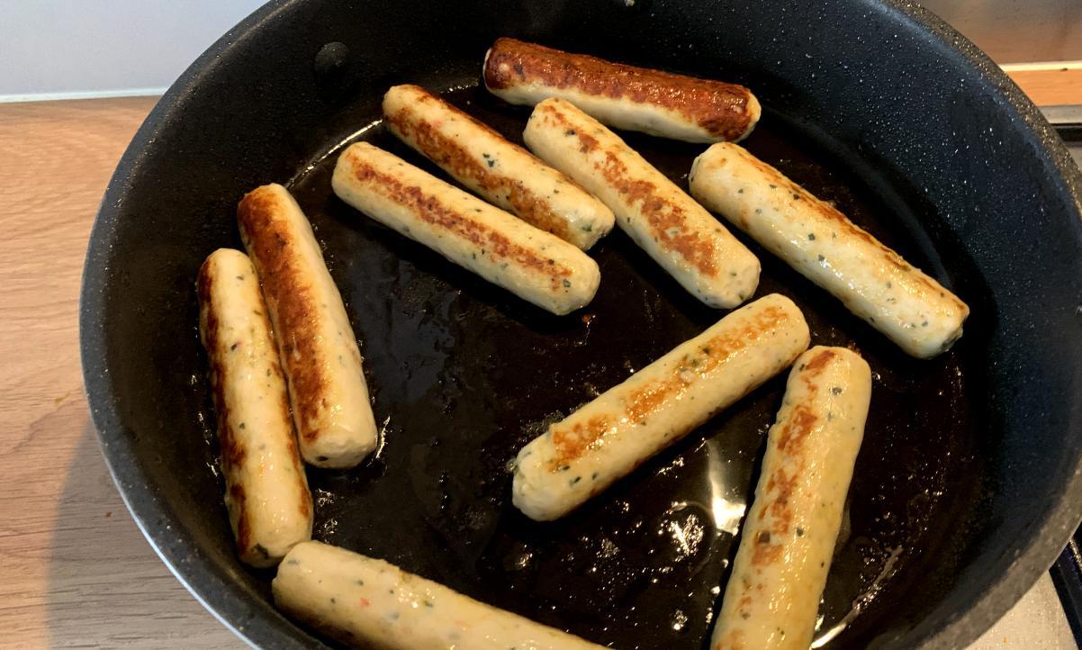 Heck chicken sausages frying in a pan