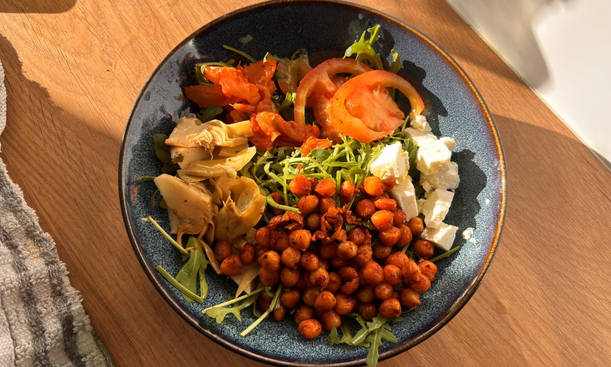 pan fried chickpea salad in a blue bowl with feta, tomatoes and rocket