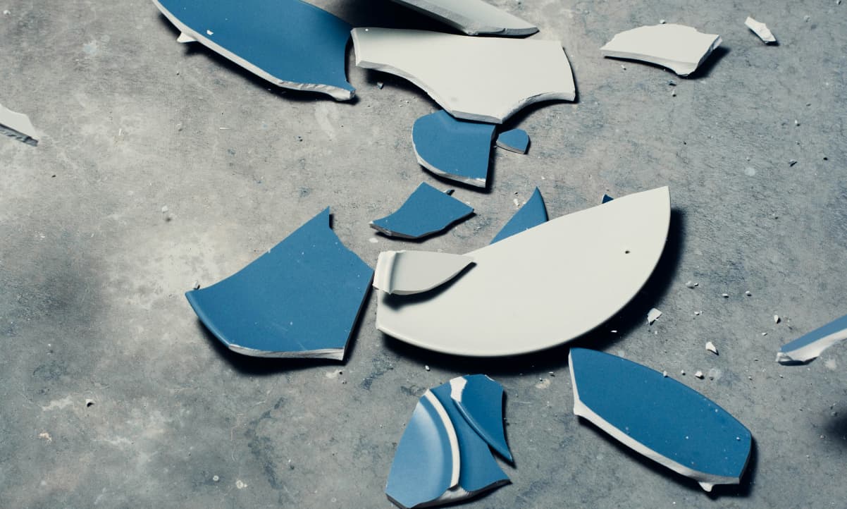 a blue and white ceramic plate broken on the ground