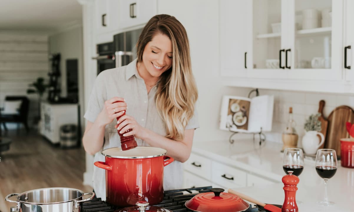 a smiling woman cooking in a clean kitchen