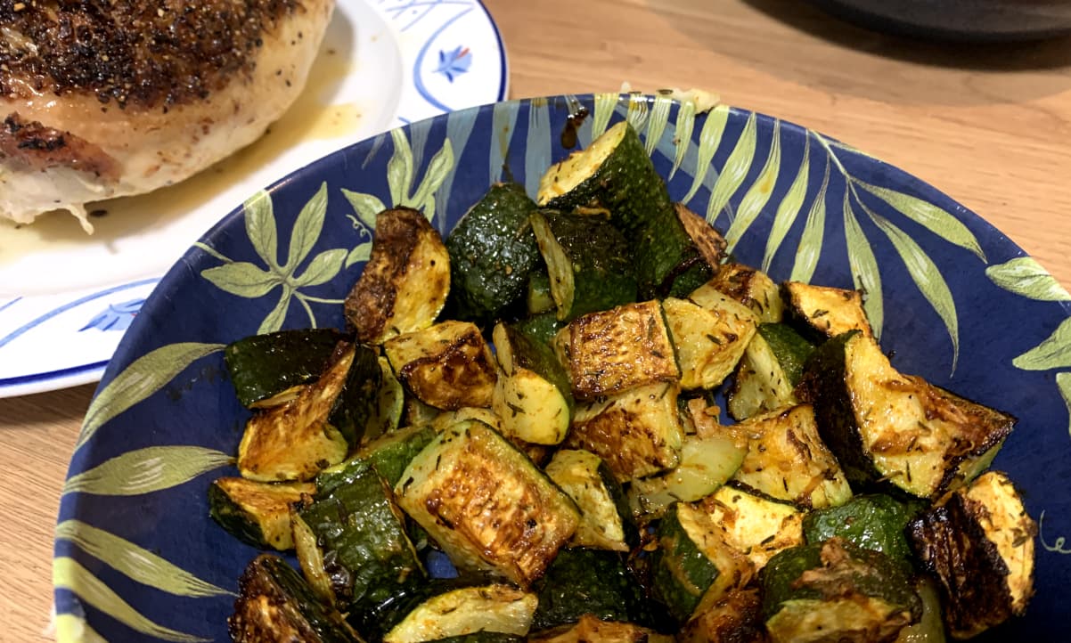 roasted courgette side dish with thyme in a blue and green bowl