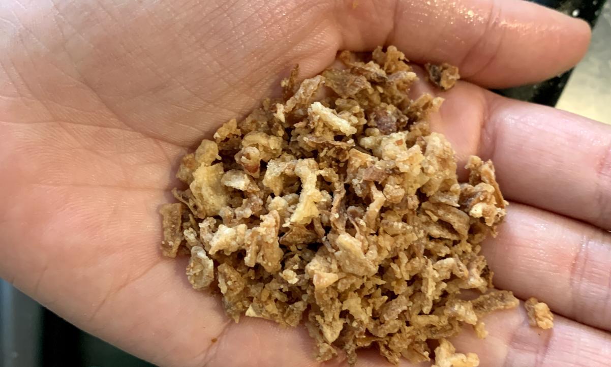 crispy onion flakes on the palm of someone's hand