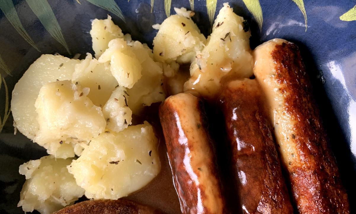 healthy bangers and mash, consisting of seasoned potatoes, gravy, and chicken sausages