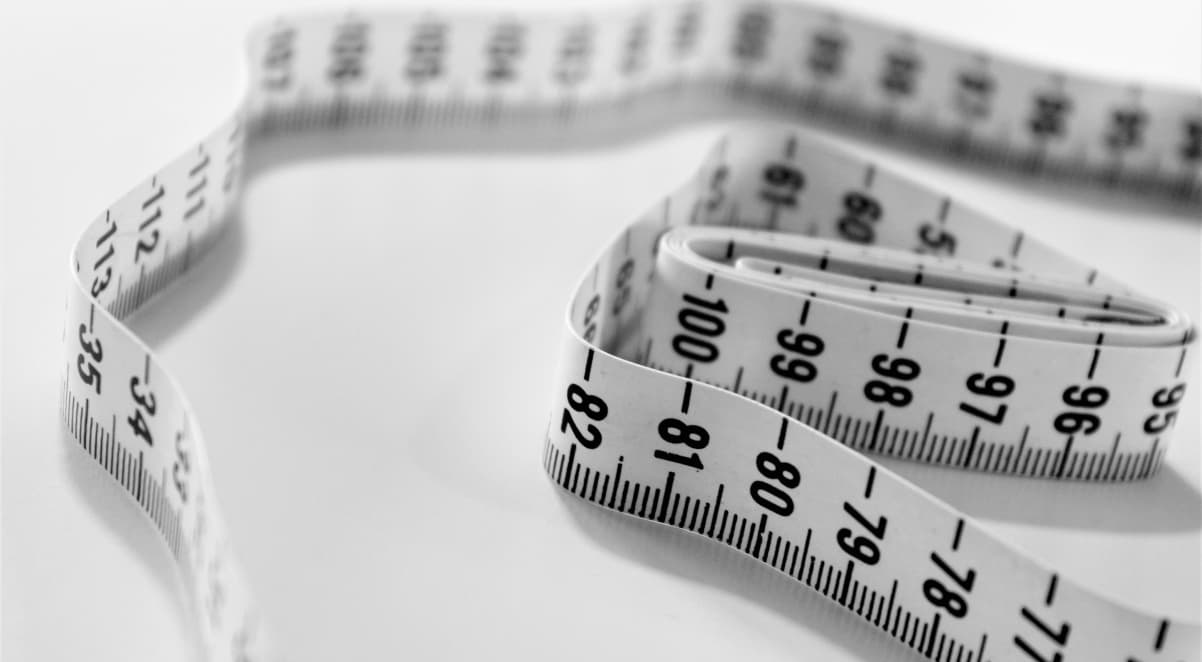 a measuring tape, partially unfurled, on a white table