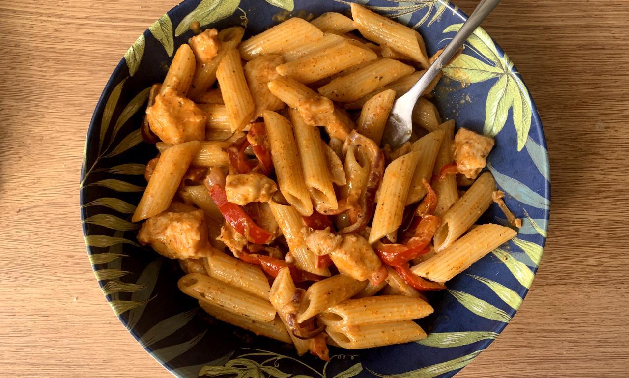 chicken fajita pasta in a blue and green bowl