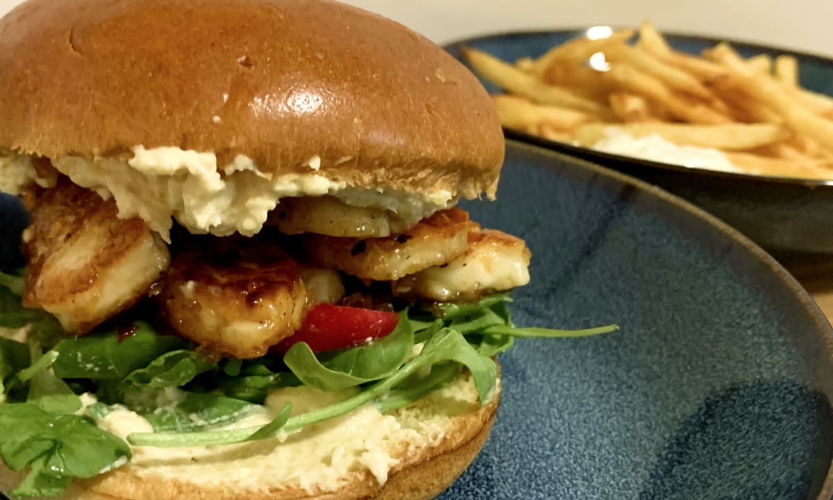 a closeup of a filling halloumi burger with sweet chilli and hummus