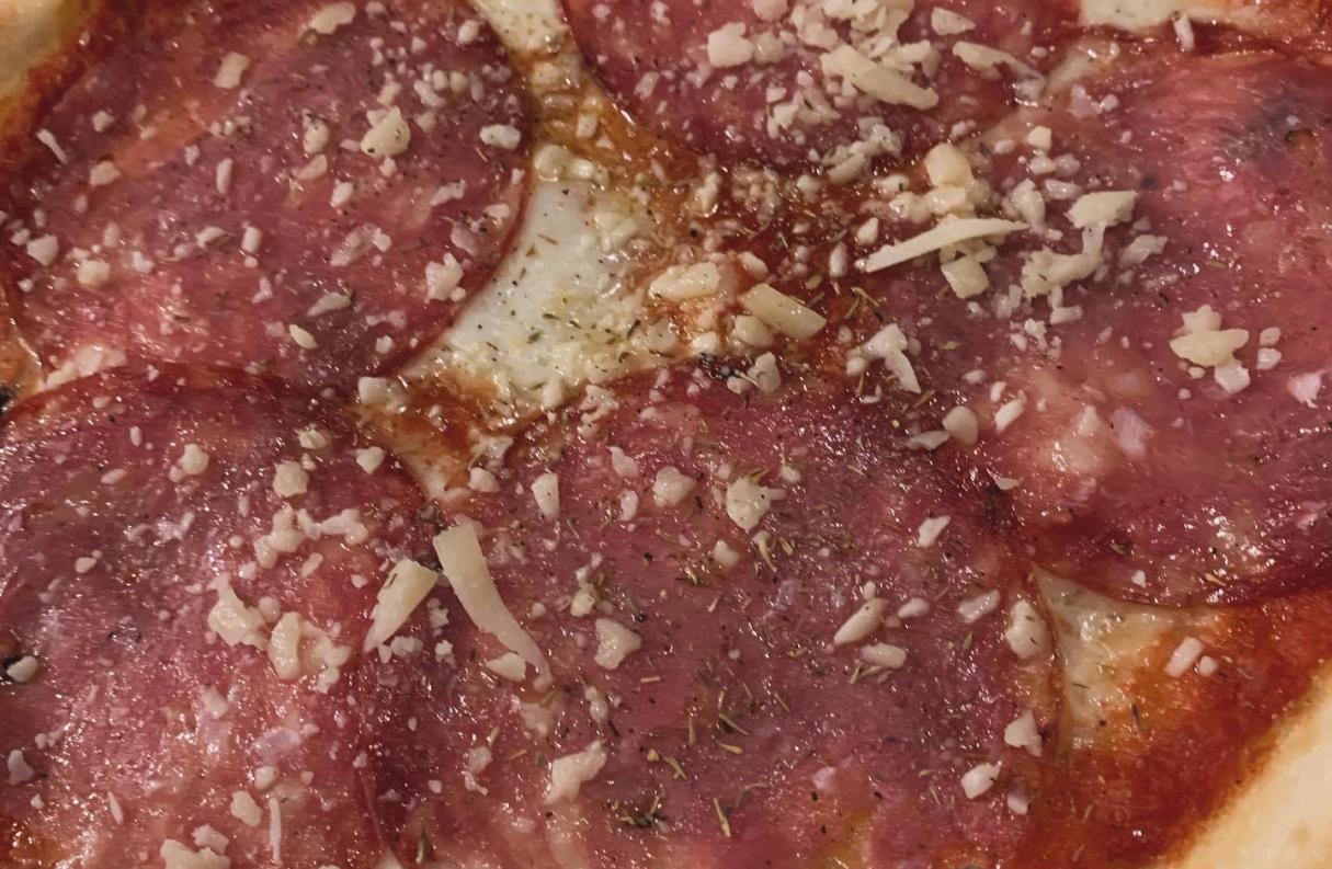 salame and grated grana on a pizza