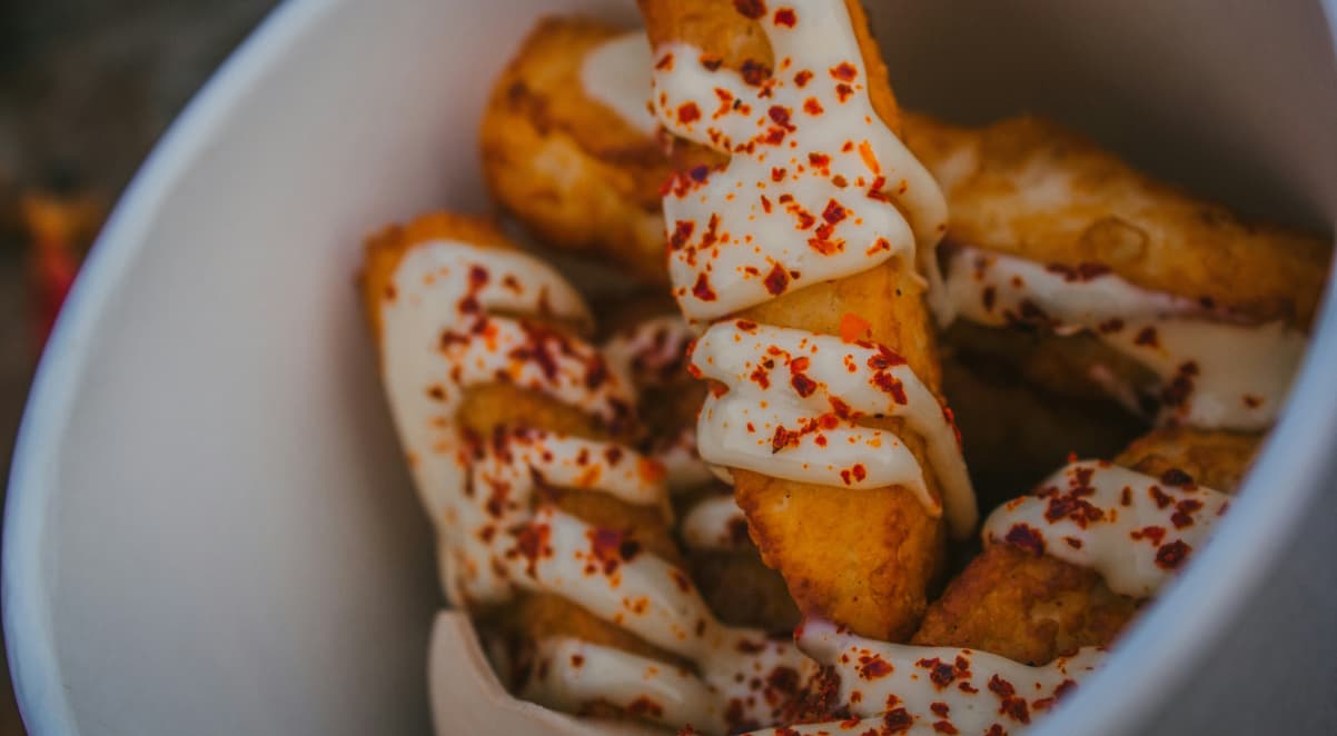 halloumi fries with white sauce and red chilli flakes on top