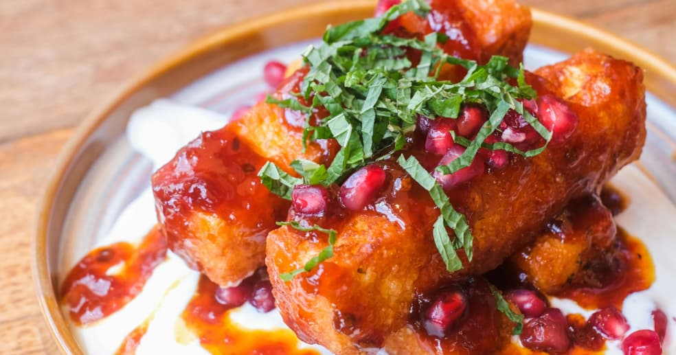 halloumi fries with sweet chilli sauce and pomegranate seeds on a restaurant plate