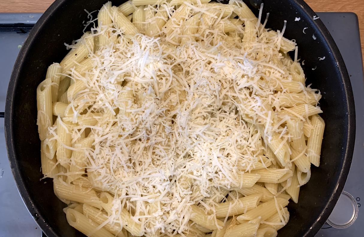 aglio e olio with penne, garnished with parmigiano