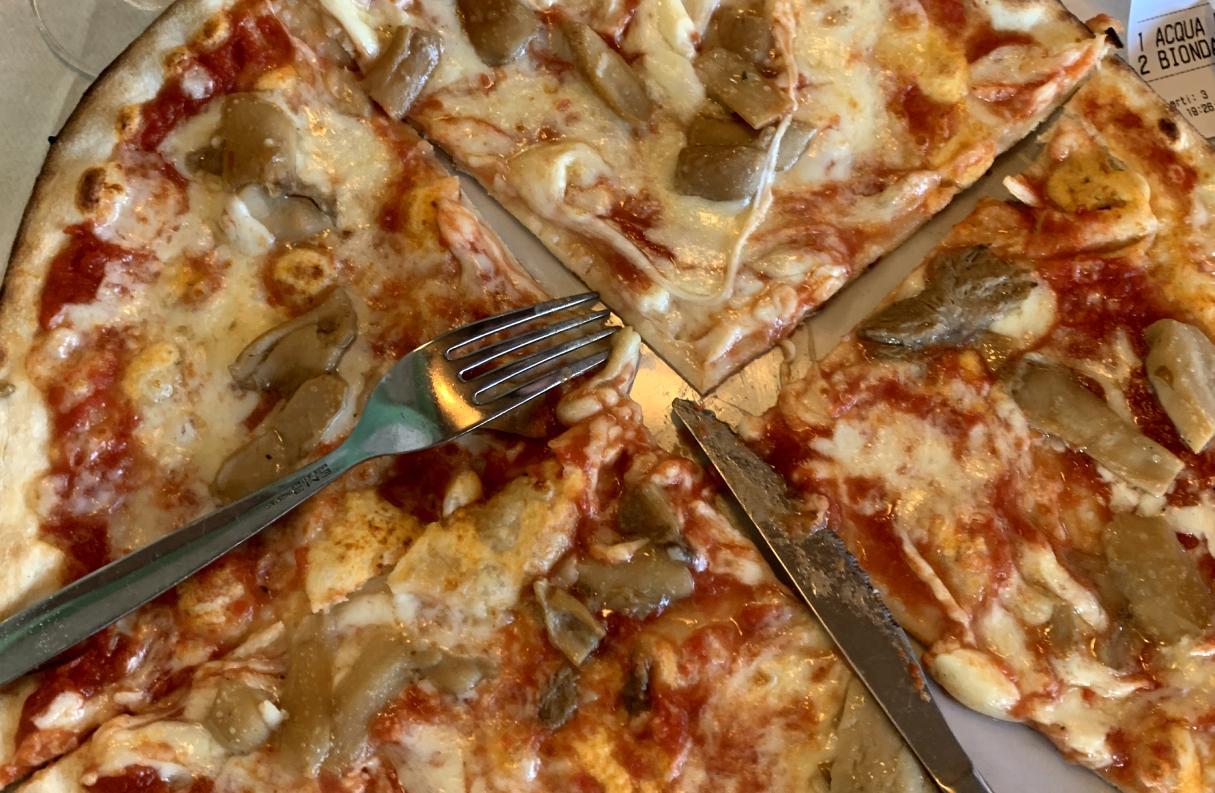 a closeup of a pizza with a classic northern italian pizza topping of porcini mushrooms 