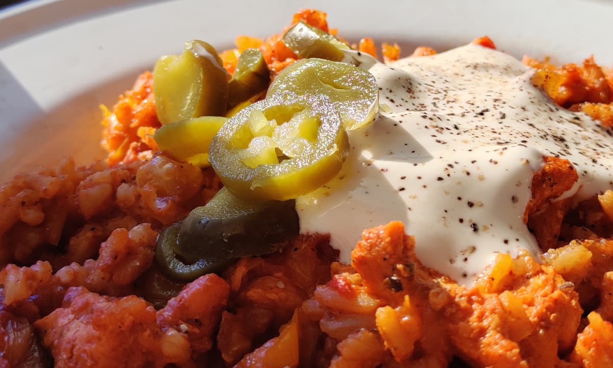 closeup of red rice with jalapenos and creme fraiche