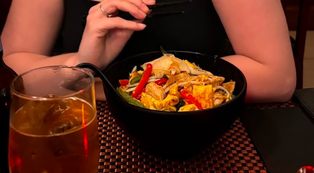 a bowl of brightly coloured vegetables, chicken, egg, and pickled ginger