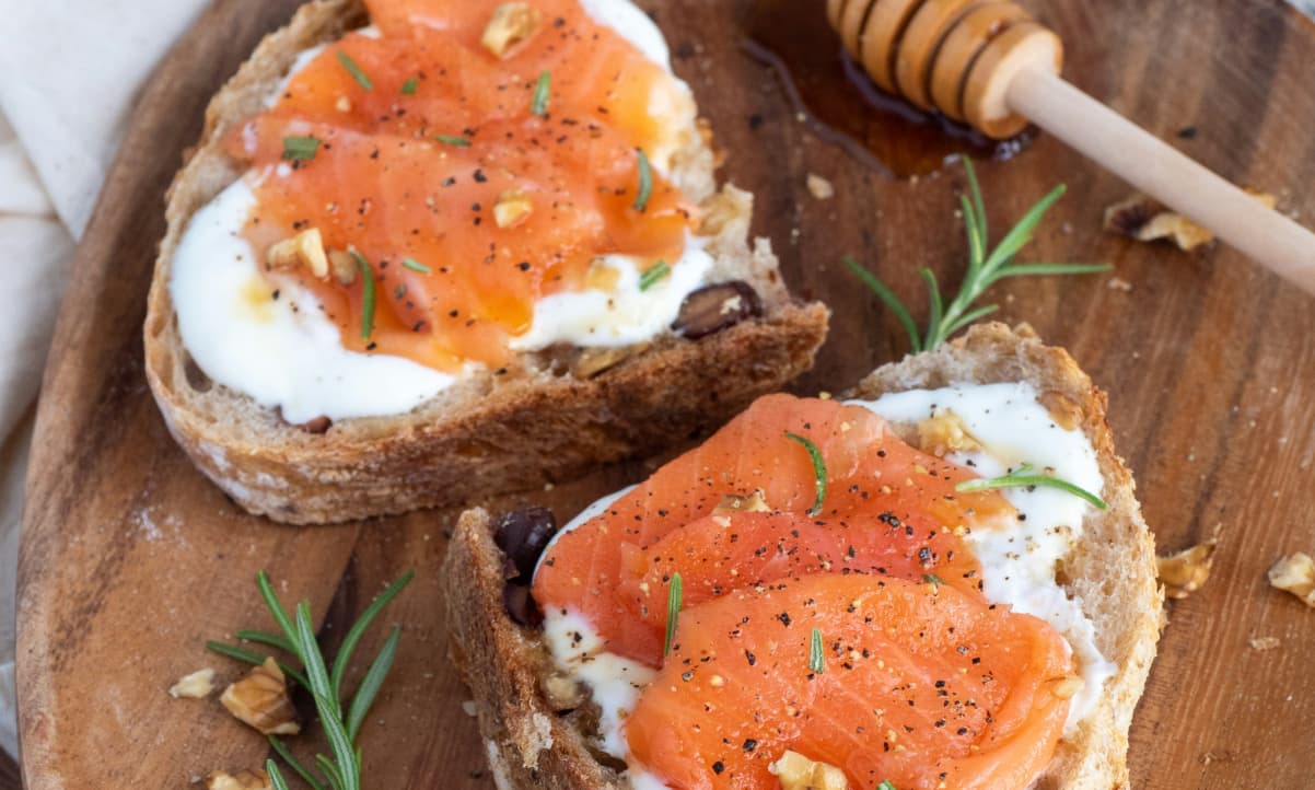 smoked salmon folded onto toasted bread with cream cheese and rosemary