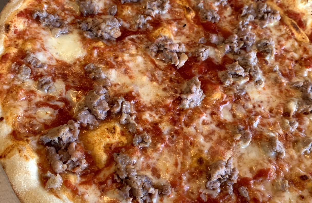 Italian pizza with traditional topping of crumbled sausage