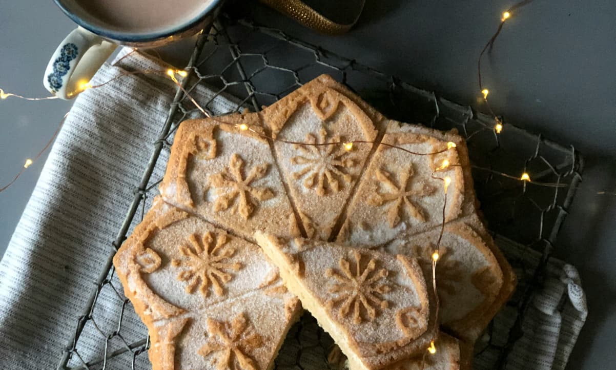 a large star shaped piece of shortbread cooling on a wire rack