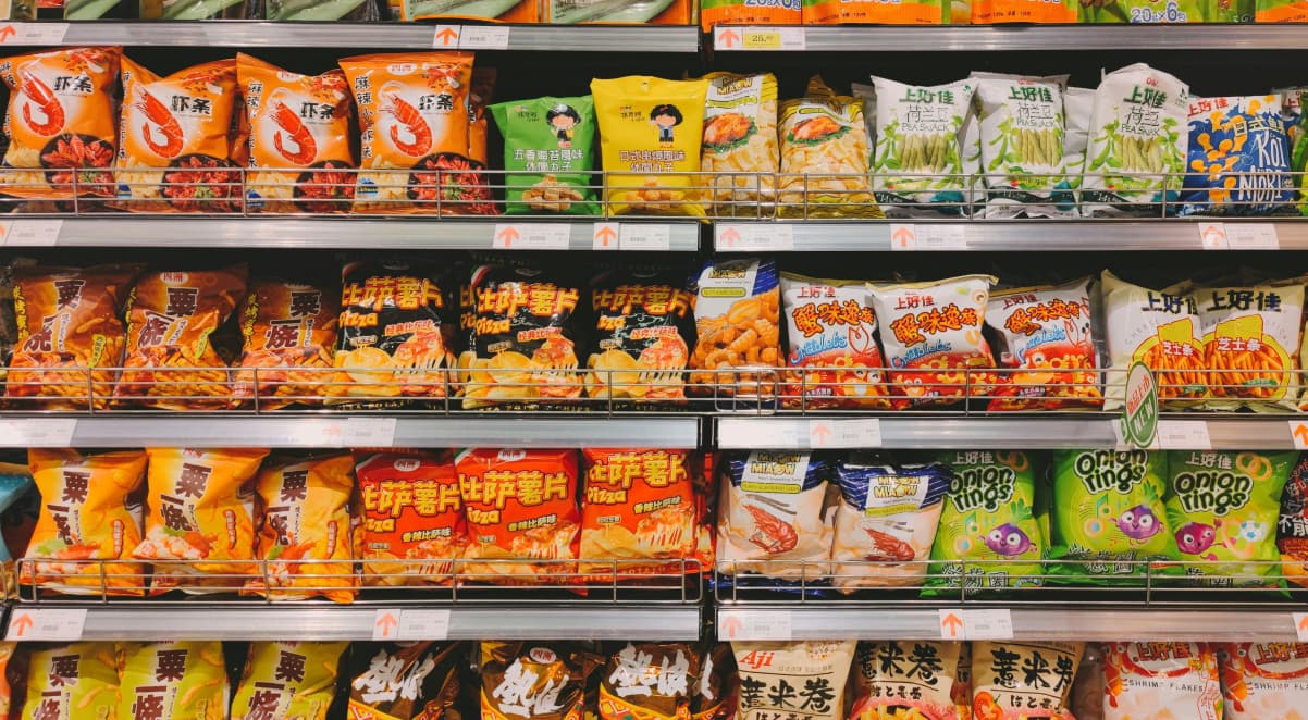 a selection of snacks on supermarket shelves in brightly coloured packets