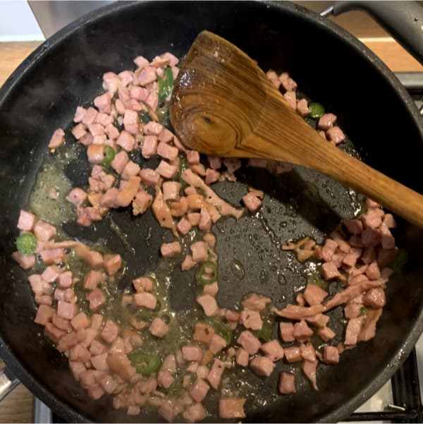 bacon lardons and chilli slices frying in a pan