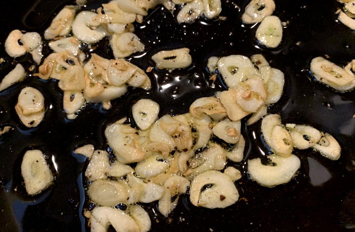 thinly sliced garlic, slightly golden at the edges, frying in oil