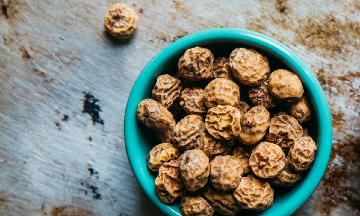 shrivelled round fruits, tiger nuts, in a small blue bowl