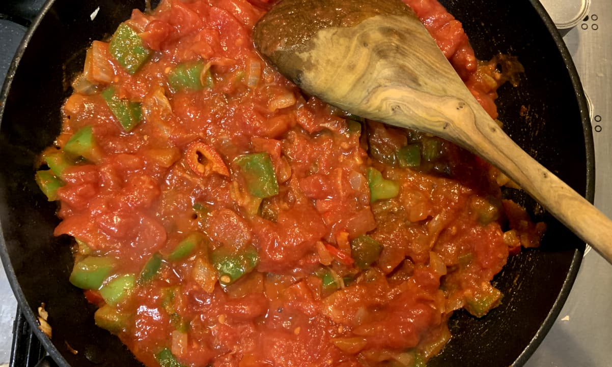 chopped tomatoes cooking with chunks of green pepper