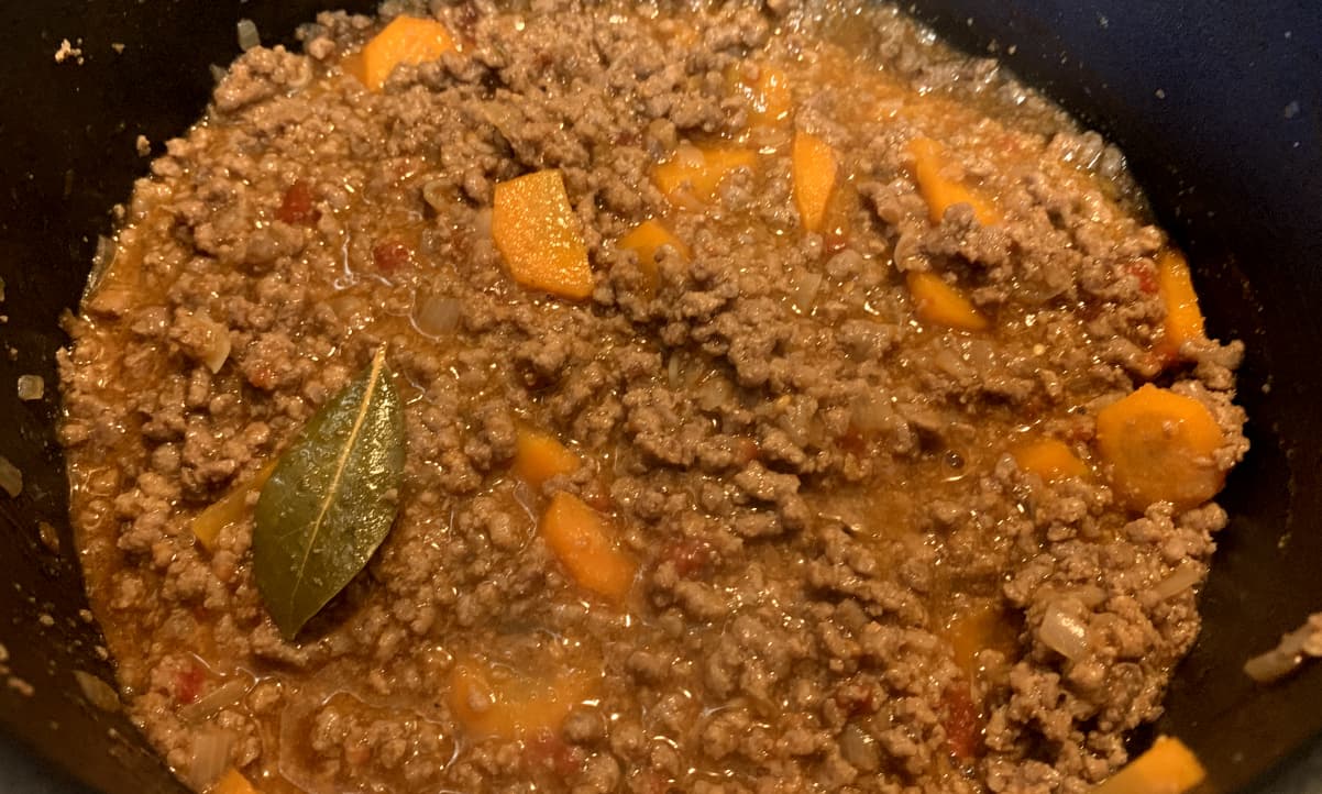 mince, carrots and a bayleaf cooking in a pot